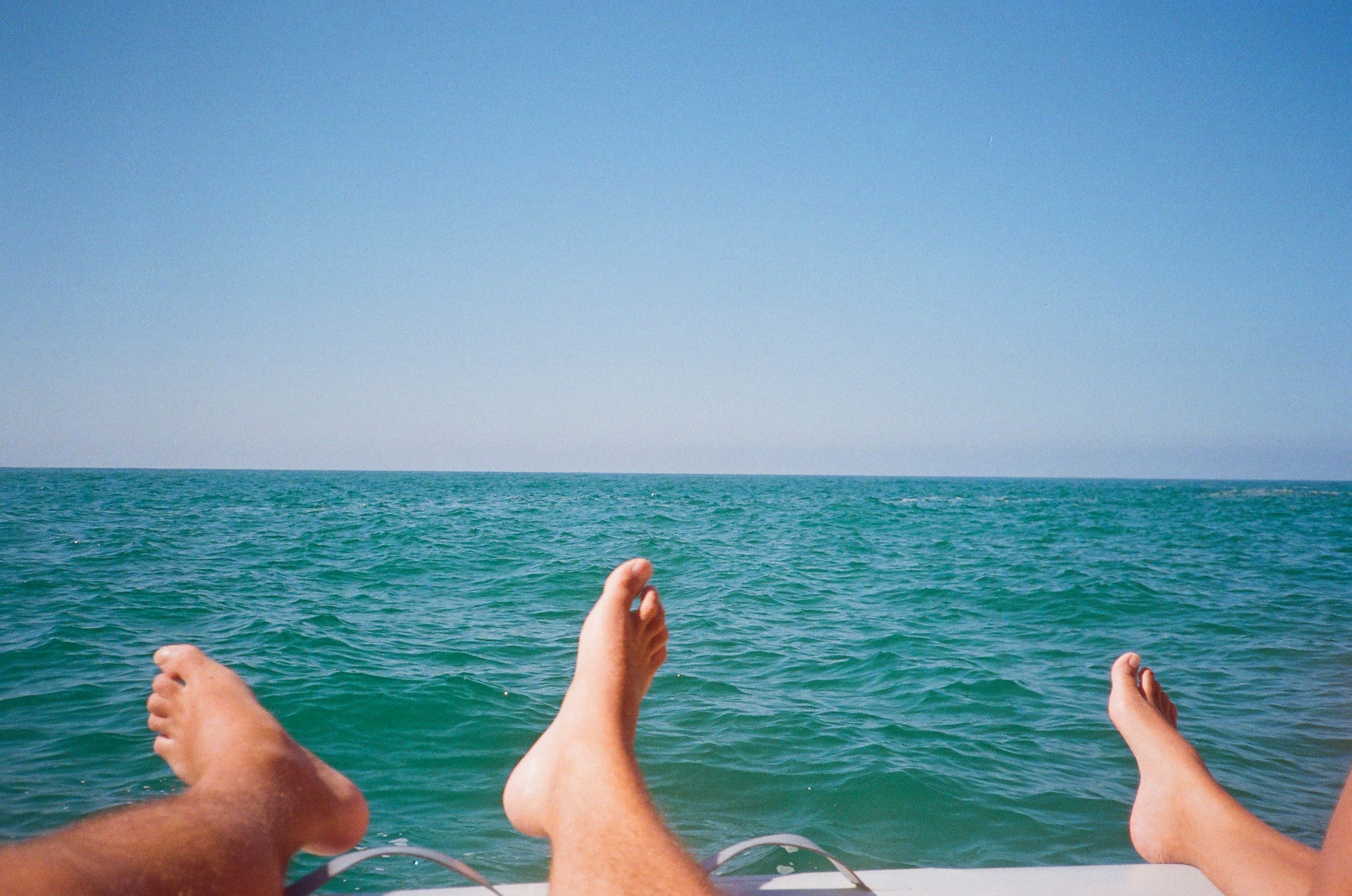 Travellers relaxing beside clear blue water